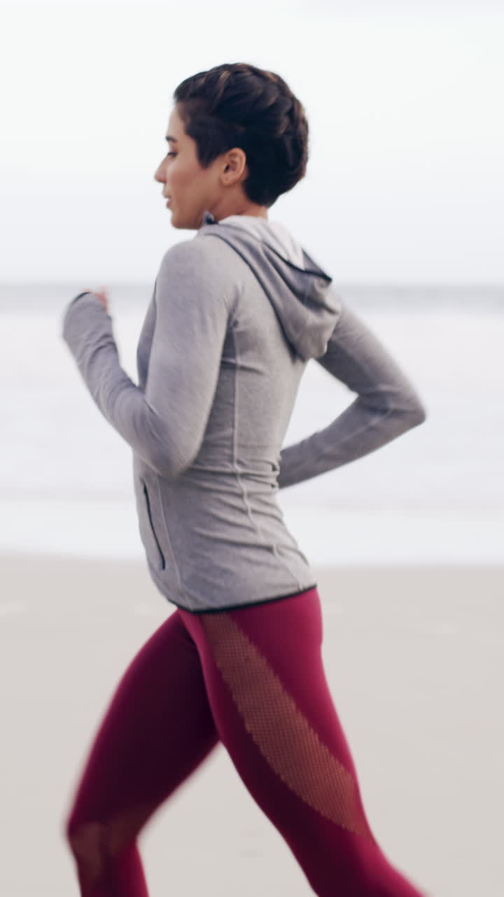 Donna in forma che fa jogging lungo la battigia