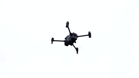 high performance drone silhouette hover in bright white sky, czechia