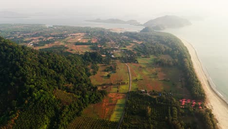 sweeping aerial over laem son park coast with green forest meeting turquoise sea