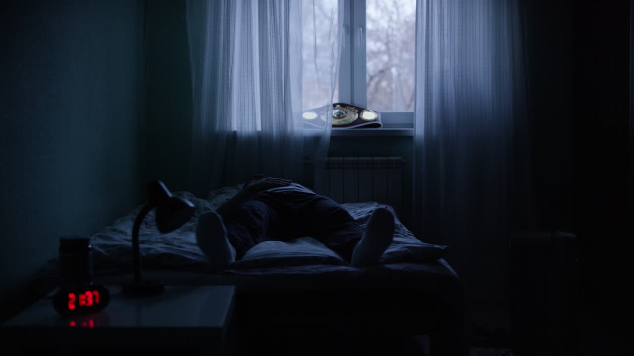 hombre durmiendo en un dormitorio oscuro