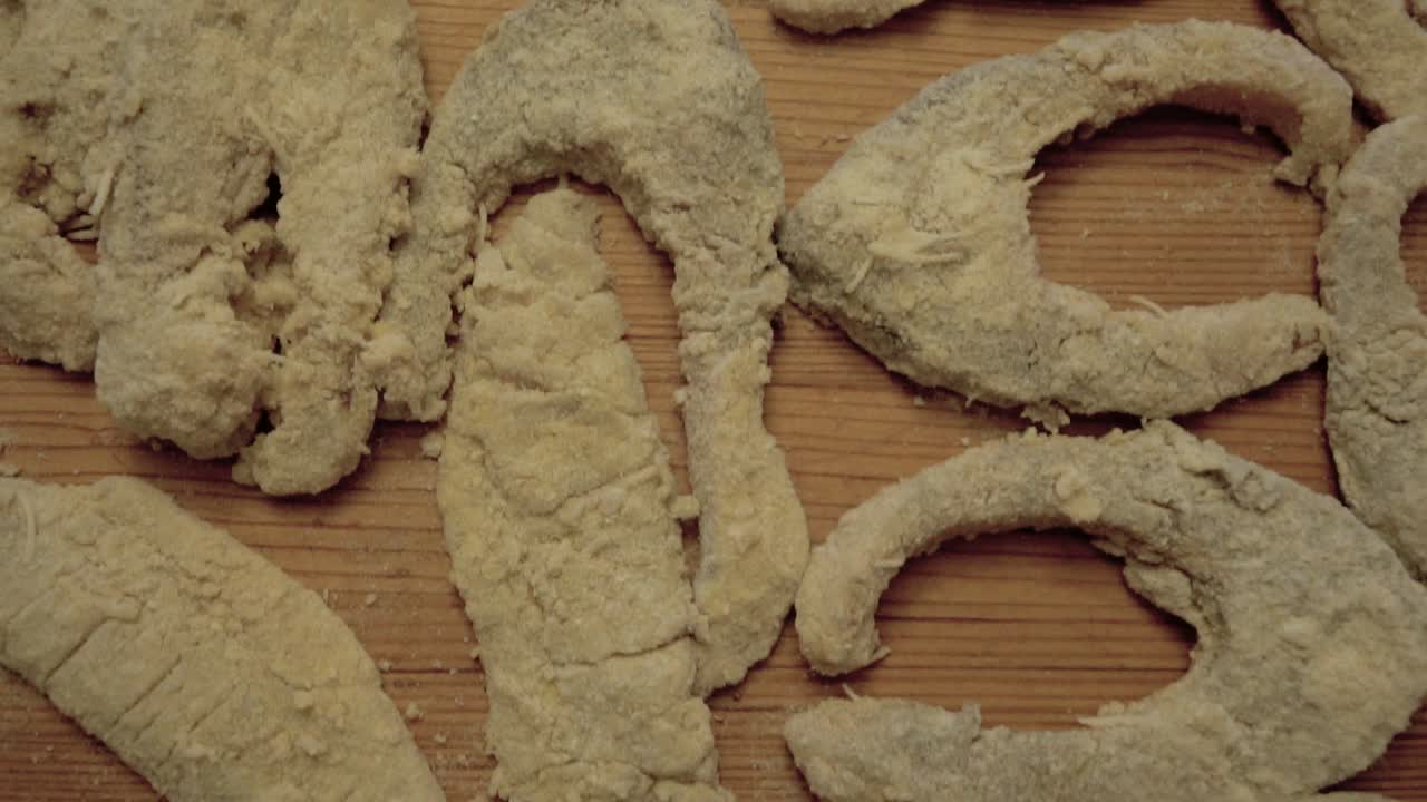 커팅 보드에 놓인 빵가루를 입힌 생선 조각을 아래로 미끄러지는 머리 위