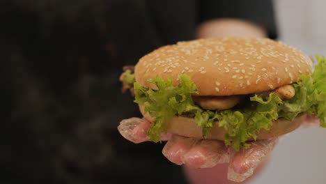 burger in cook hand with greens and cutlet