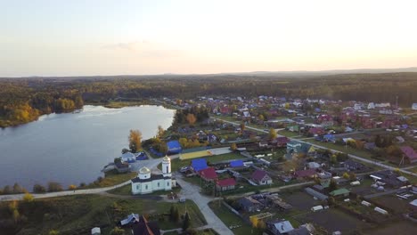 aerial view of a russian village by a lake with a church