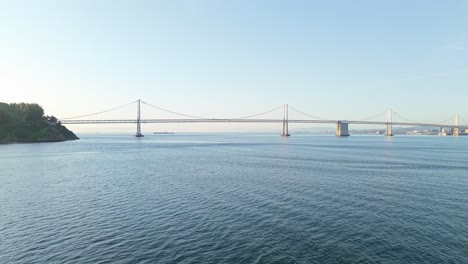 low morning sun adds warmth while the bay bridge arches toward san francisco.