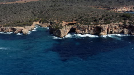 Costa-Rocosa-De-Mallorca-Con-Mar-Azul-Oscuro,-Olas-Y-Acantilados-Erosionados