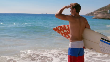 handsome man standing with surfboard