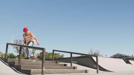 caucasian man riding and jumping on skateboard on sunny day