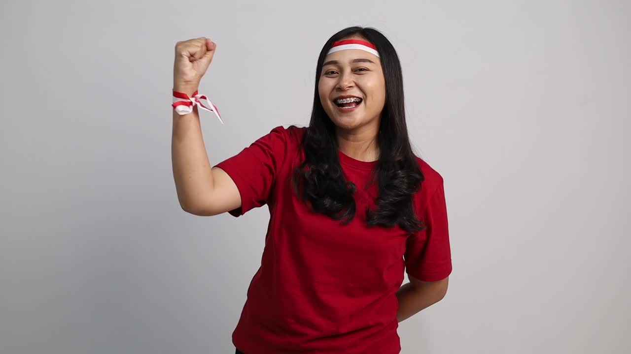 Asian woman clenching hands, celebrates Indonesia independence day, isolated over white background