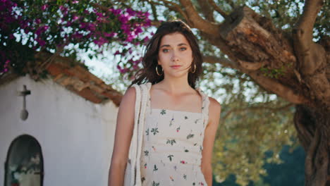 retrato de una chica posando en la iglesia del jardín de verano. mujer tocando el cabello mirando a la cámara