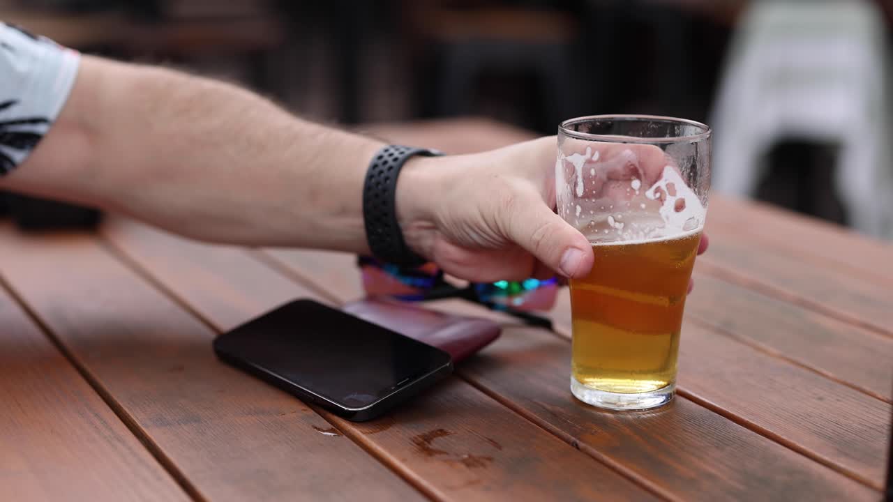 persona disfrutando de una cerveza sola en una mesa de madera