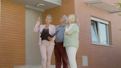 real estate agent presenting senior couple house for buying