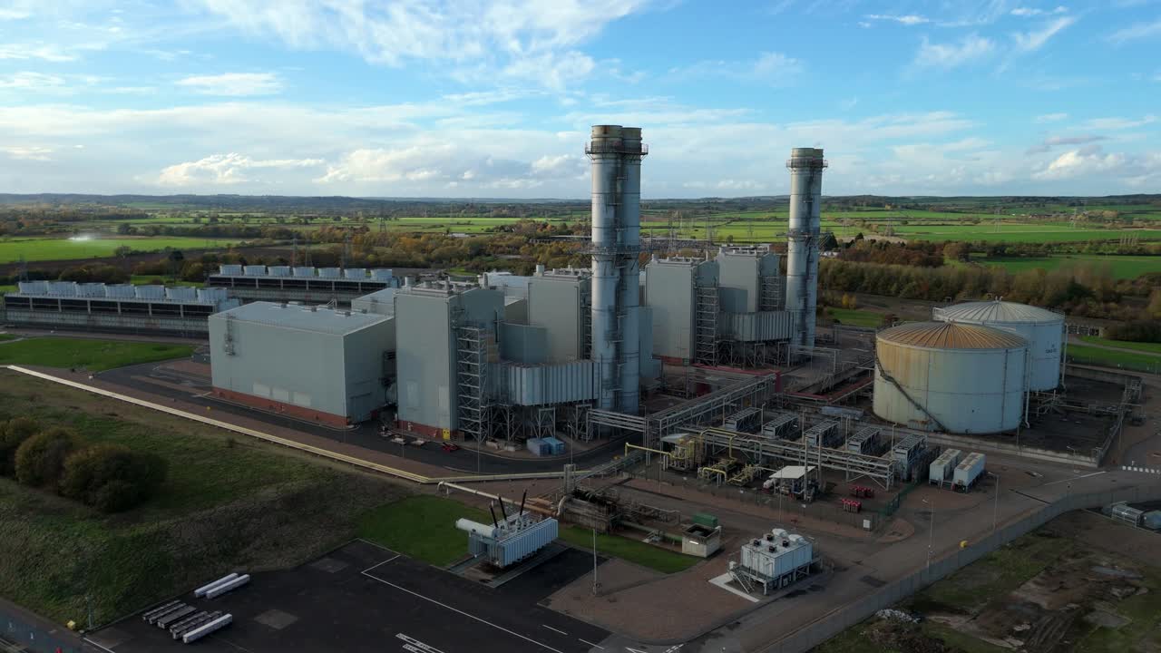 Drone aerial view of gas energy plant with turbines cooling systems and chimney stacks near Newark at sunset