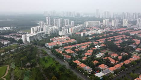 Dolly-Drone-Sobre-El-Horizonte-Y-Las-Casas-Del-Distrito-7-De-La-Ciudad-De-Ho-Chi-Minh,-Día-Brumoso