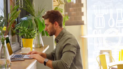 Handsome-man-using-laptop-at-table-4k