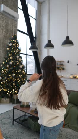 woman posing by a decorated christmas tree