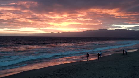 costa de santa bárbara california durante la puesta de sol mientras la gente pasea por la playa, amplia toma de mano