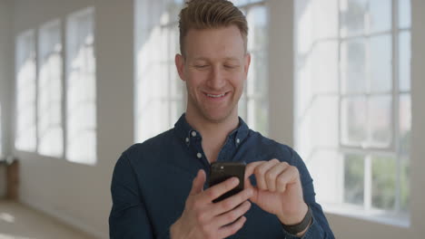 Retrato-De-Un-Joven-Apuesto-Usando-Teléfonos-Inteligentes-Enviando-Mensajes-De-Texto-Navegando-En-Línea-Disfrutando-De-La-Lectura-De-Mensajes-Trabajando-Con-Tecnología-Bancaria-De-Teléfonos-Móviles-En-El-Fondo-De-Las-Ventanas-De-Los-Apartamentos