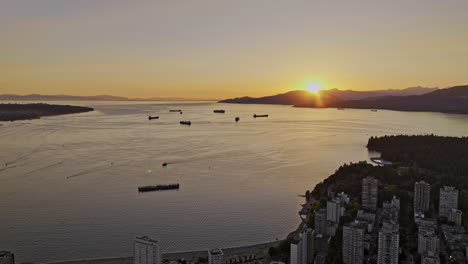 vancouver bc canada aerial v62 reserve flyover west end neighborhood capturing english bay beach, burrard inlet, mountain and views of the sunset over the bay - shot with mavic 3 pro cine - july 2023