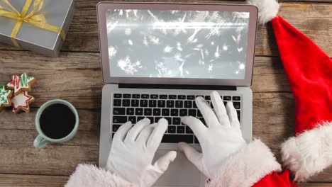 santa using laptop with christmas snowflakes