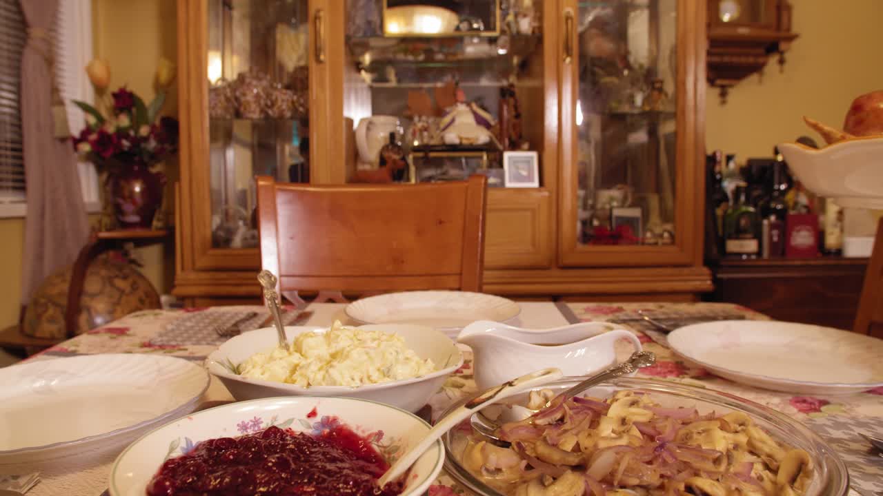 추수 감사절 칠면조를 음식으로 가득 찬 테이블에 놓고 슬로우 모션 4k로 잔치를 준비합니다.