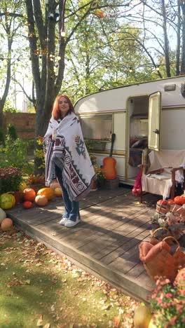 woman enjoying a cozy autumn afternoon by an rv