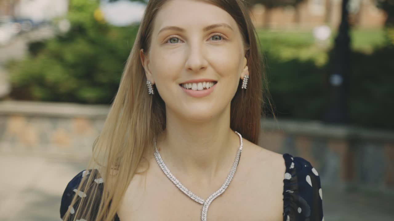 mujer de cabello rubio muy largo posando sonriendo directamente a la cámara - cámara lenta de primer plano