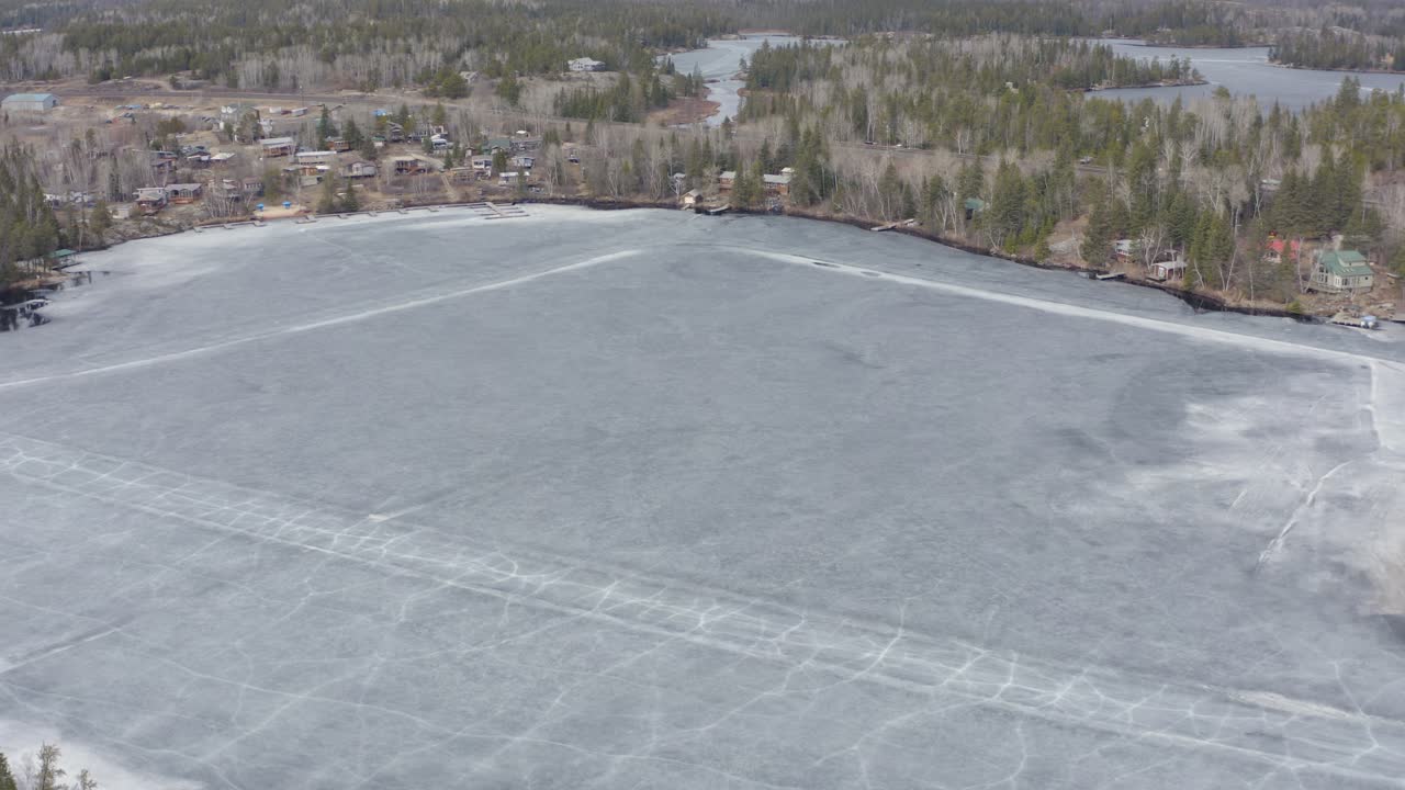 círculo aéreo dejado sobre el lago congelado derritiéndose con grietas en los caminos de hielo aún visibles en canadá