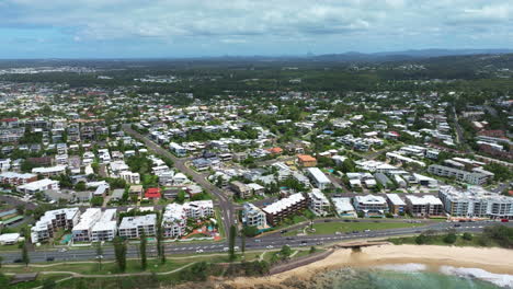 Flyover-Scenic-Coastal-Town-With-Beach-And-Buildings,-4K-Aerial-Drone