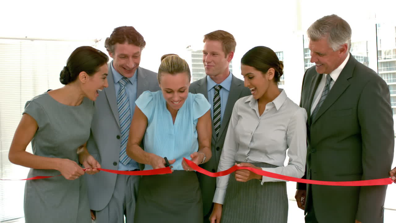 gente de negocios cortando banda roja