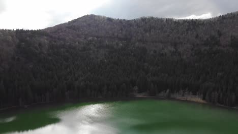 Aerial-view-of-Sfanta-Ana-Lake-in-Romania,-volcanic-lake-with-beautiful-green-water