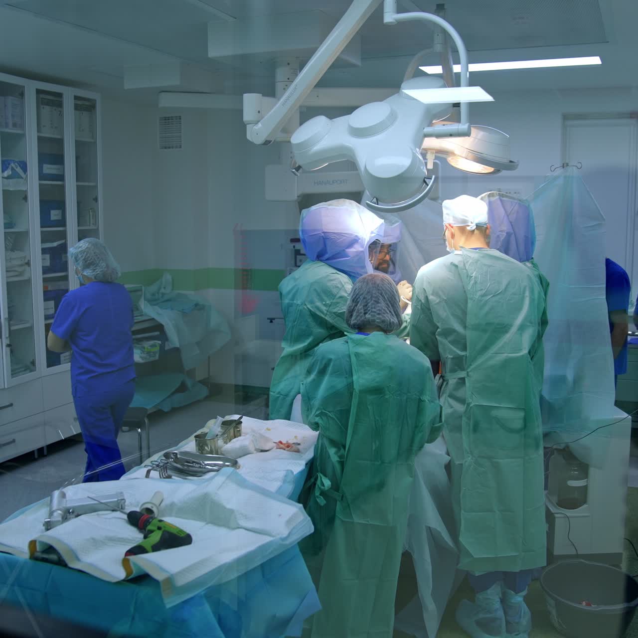 Moderne traumekirurgi i gang. Udsigt til operation udført af det medicinske team gennem dørvinduet.