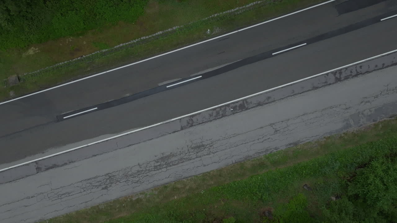 vista aérea de una furgoneta blanca conduciendo en una carretera del país