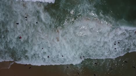 drone con cámara apuntando hacia abajo y filmando olas y espuma en el mar en la playa de ipanema, brasil