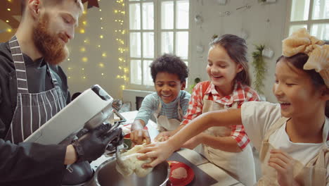 Niños-Tomando-Masa-Del-Tazón-De-La-Batidora-Durante-La-Clase-Magistral-De-Cocina