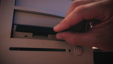 inserting a floppy disk into an old computer