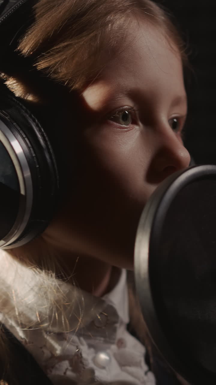 chica participa en una sesión de grabación. miembro de la generación más joven canta en el estudio para el lanzamiento de la primera canción. pequeña chica rubia en una actuación musical