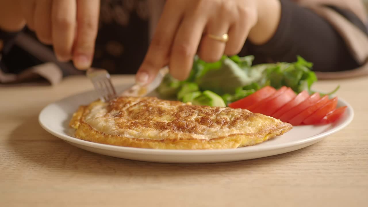 mujer comiendo una tortilla con verduras