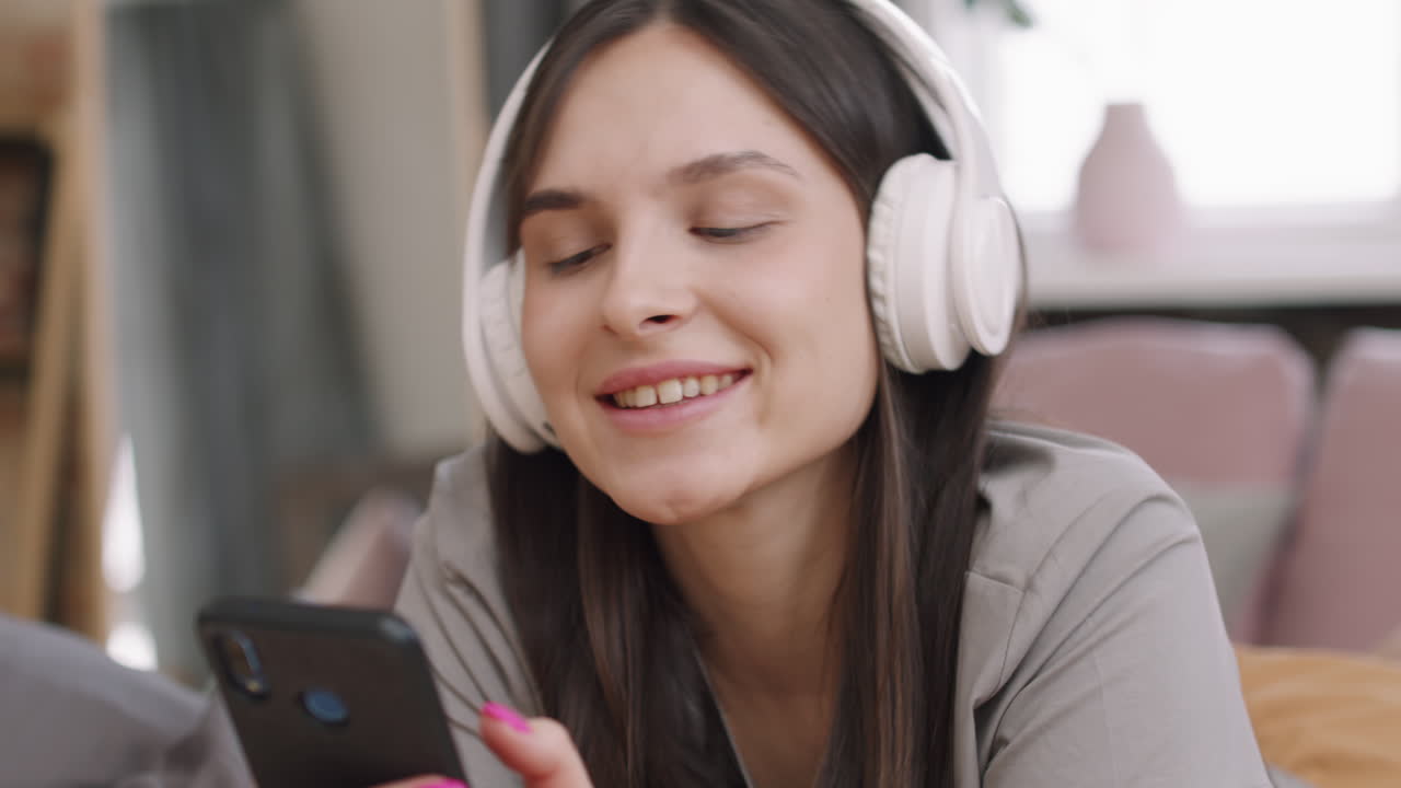 Happy Woman in Headphones Enjoying Music at Home
