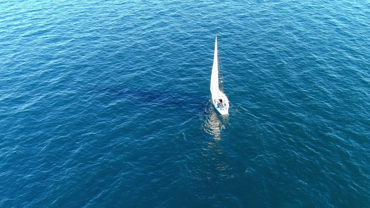 velero navegando en el océano pacífico frente a la costa de pacific palisades california | toma aérea estable | tarde soleada
