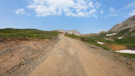 POV-while-driving-on-4WD-trail-near-Black-Bear-Pass-through-an-alpine-meadow