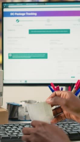 vertical video african american man using scanner to process barcode and stick shipping labels
