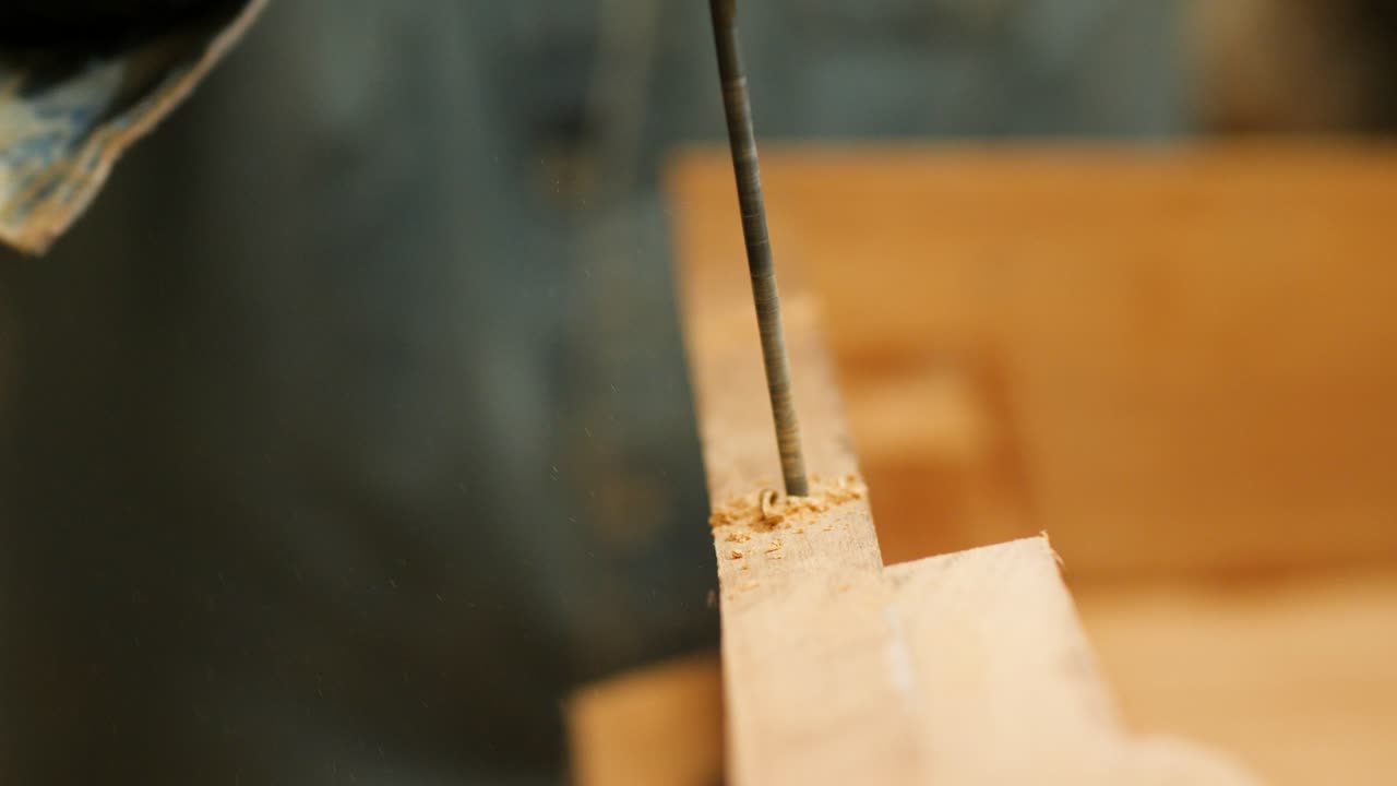 Carpenter drilling into a wooden transom for a secure and precise fit