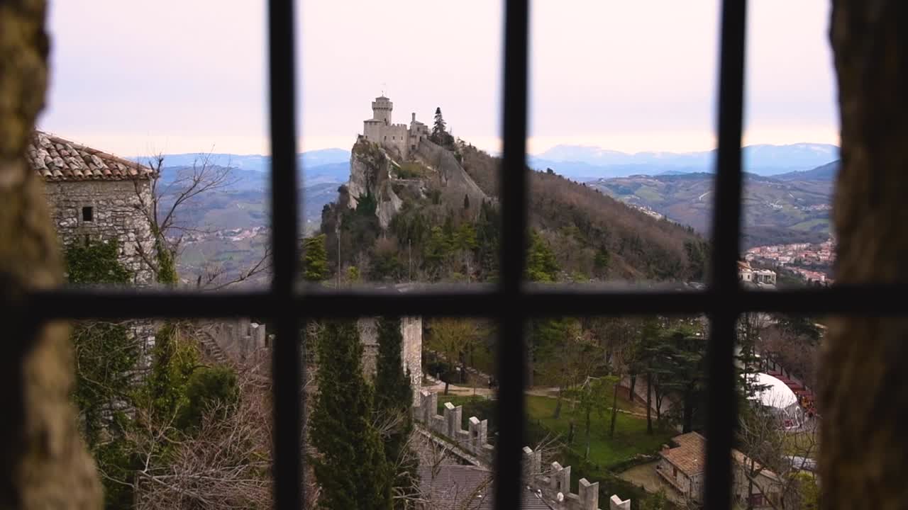 vista panorámica desde una ventana con barras de la antigua fortaleza medieval de san marino en un día nublado de invierno