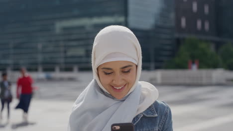 Porträt-Einer-Schönen-Jungen-Muslimischen-Touristenfrau,-Die-Ihr-Smartphone-Benutzt-Und-Ein-Selfie-Foto-Macht,-Das-Glücklich-In-Der-Stadt-Posiert-Und-Stadtreisen-Genießt,-Die-Erfahrung-Teilen,-Indem-Sie-Hijab-Kopftuch-In-Zeitlupe-Trägt