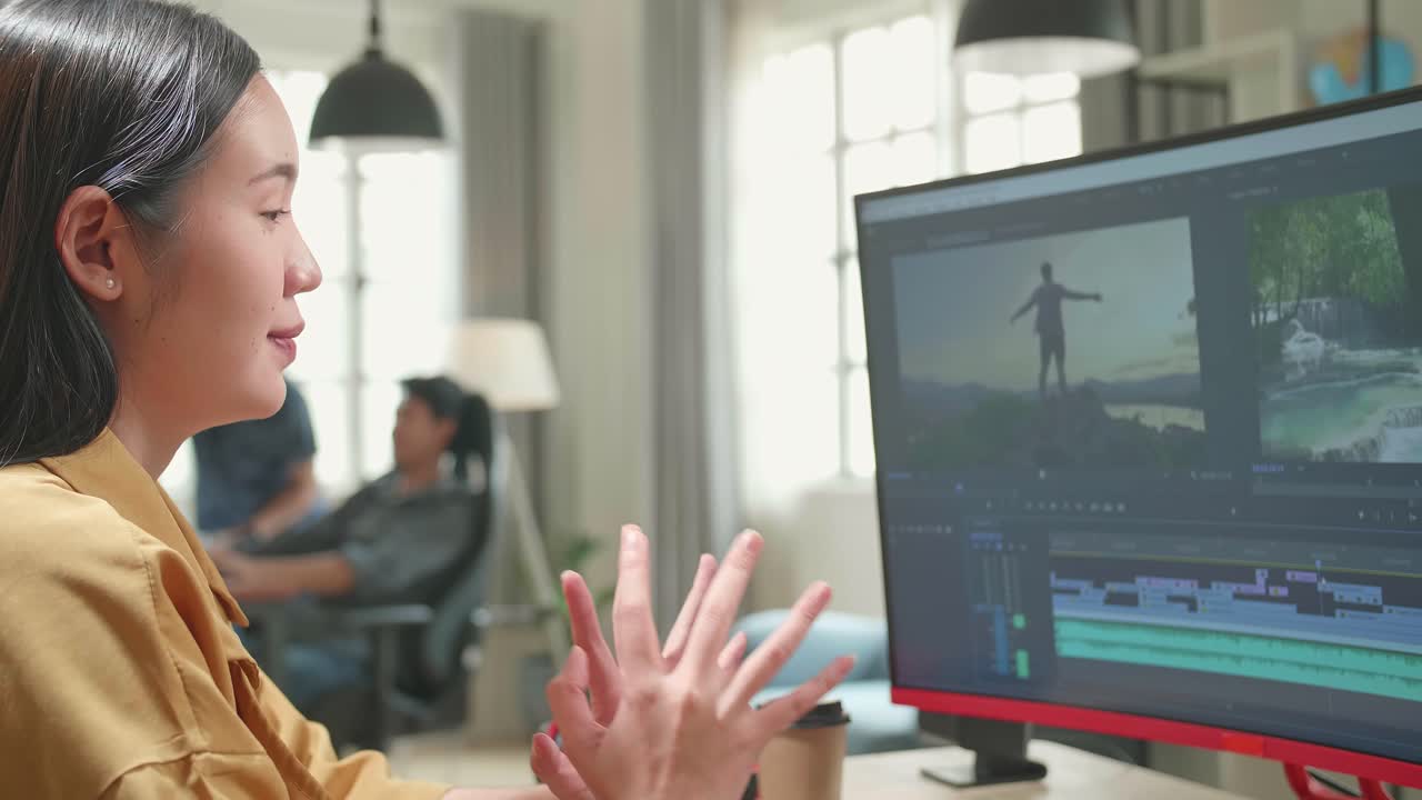 Asian Female Video Editor Stretching While Works With Footage And Sound On Her Personal Computer In Office