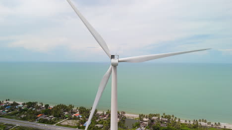 sustainable renewable green clean energy, kinetic wind energy turbine by the coast of the tropical sea