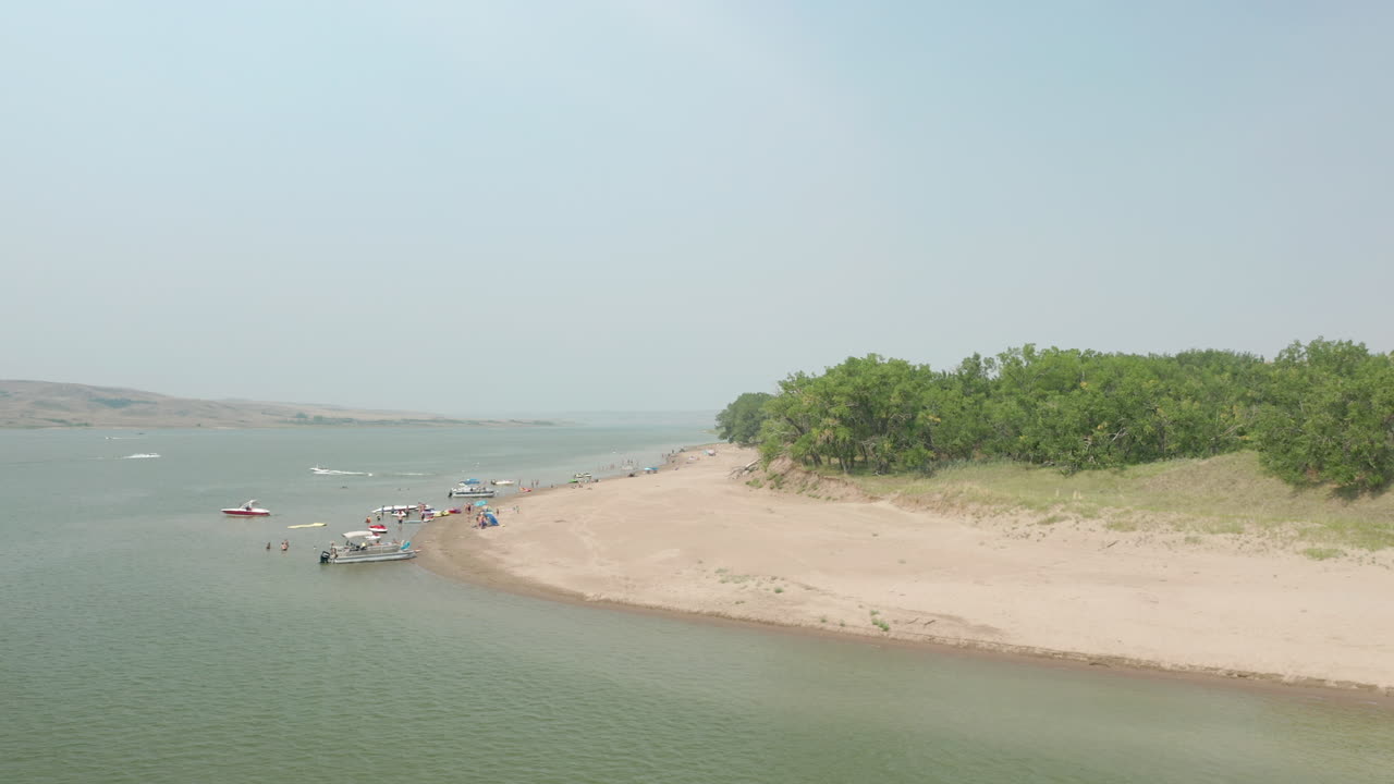 Parco Provinciale di Saskatchewan Landing con barche e turisti sulla riva sabbiosa del Lago Diefenbaker nel Saskatchewan, Canada