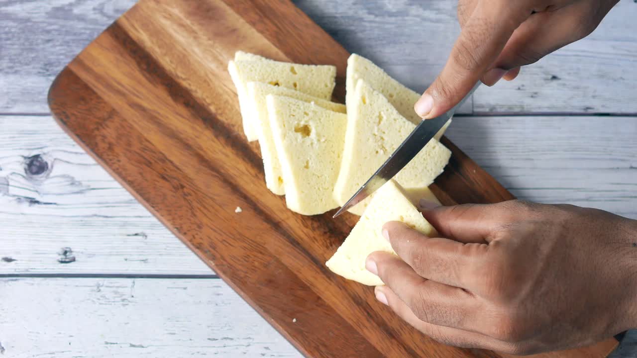 cortar queso en rodajas en una tabla de madera