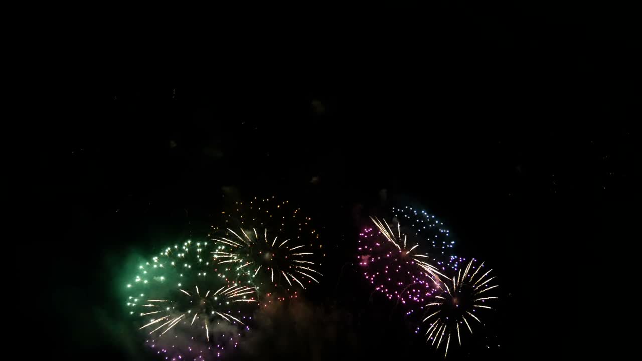 4K loop of beautiful real shining fireworks long shot 49s for celebration background. golden glowing firework during new year's eve countdown festival in the sky display at night with colorful.