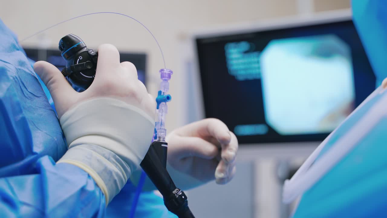 Innovative technologies in surgery. Close-up doctor's hands hold modern instrument to perform endoscopic operation in clinic.